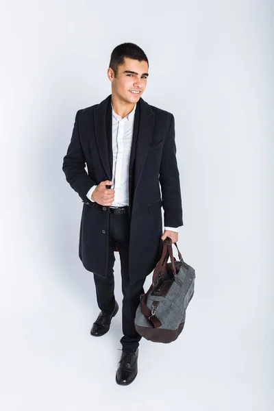 Elegante hombre en el estudio sobre un fondo blanco, con una bolsa para viajar, aislado, fondo, el hombre va en un viaje — Foto de Stock