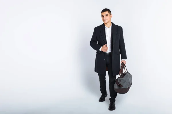 Homem elegante no Estúdio em um fundo branco, com uma bolsa para viagens, isolado, fundo, homem vai em uma viagem — Fotografia de Stock