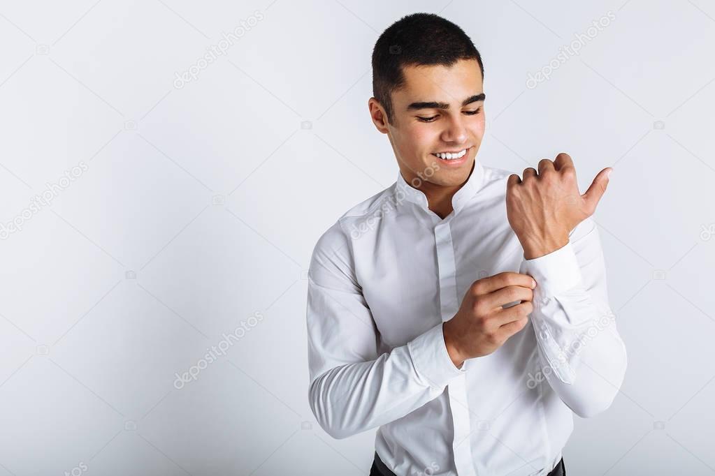 Stylish guy buttoning a button in Studio