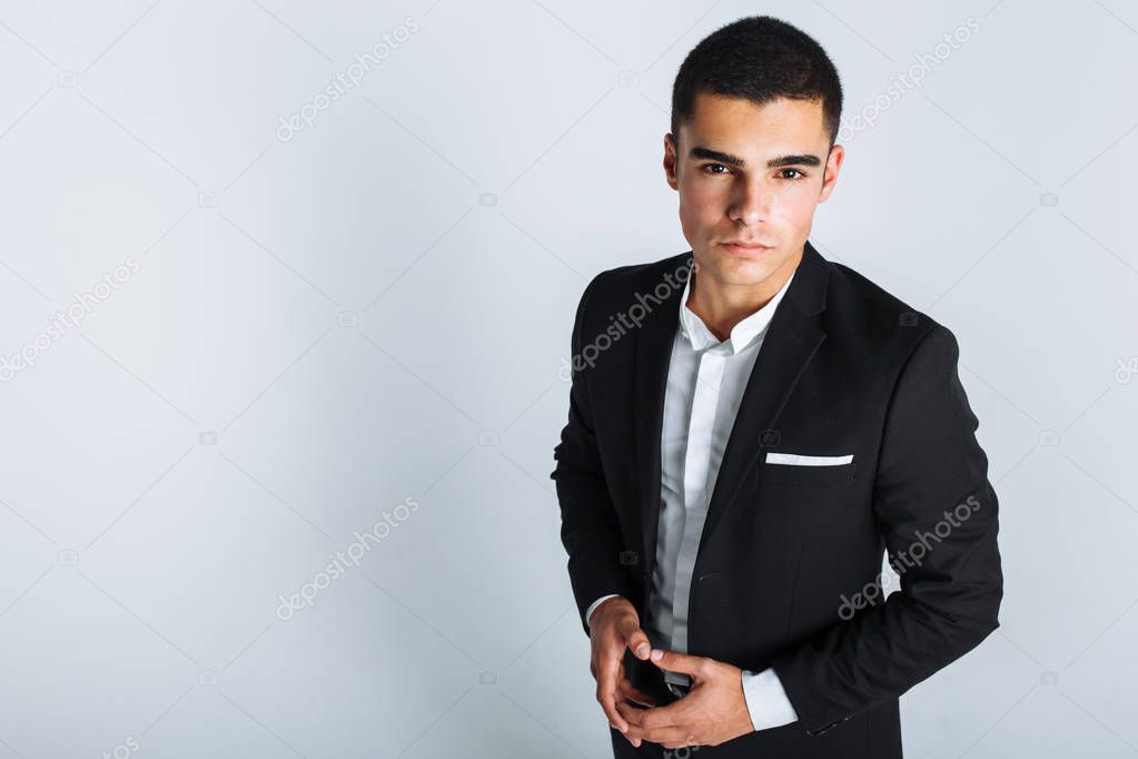 handsome young man in a stylish suit, posing on a white background isolated
