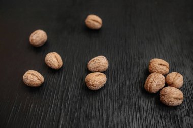 Bir sürü siyah bir ahşap zemin üzerine taze fındık. Tasarımcı için en iyi yöntemler