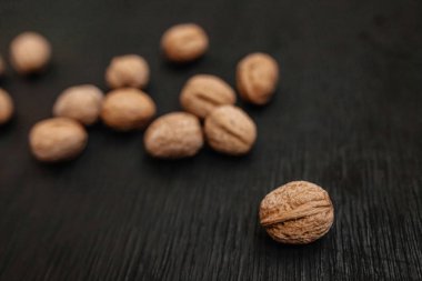 Bir sürü siyah bir ahşap zemin üzerine taze fındık. Tasarımcı için en iyi yöntemler