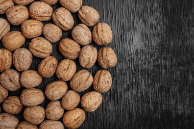 Bir sürü siyah bir ahşap zemin üzerine taze fındık. Tasarımcı için en iyi yöntemler. Fındık üzerinden güzel bir tasarım