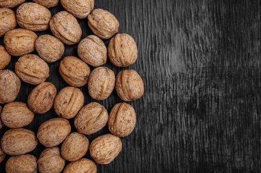 Bir sürü siyah bir ahşap zemin üzerine taze fındık. Tasarımcı için en iyi yöntemler. Fındık üzerinden güzel bir tasarım