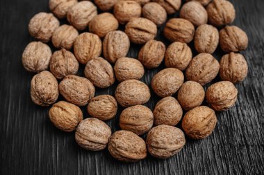 Bir sürü siyah bir ahşap zemin üzerine taze fındık. Tasarımcı için en iyi yöntemler. Fındık üzerinden güzel bir tasarım