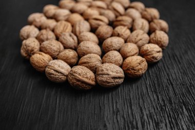 Bir sürü siyah bir ahşap zemin üzerine taze fındık. Tasarımcı için en iyi yöntemler. Fındık üzerinden güzel bir tasarım