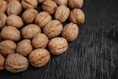 Bir sürü siyah bir ahşap zemin üzerine taze fındık. Tasarımcı için en iyi yöntemler. Fındık üzerinden güzel bir tasarım