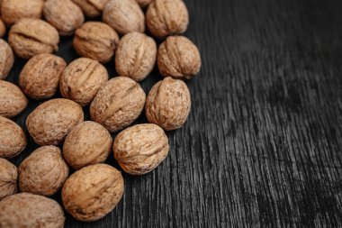 Bir sürü siyah bir ahşap zemin üzerine taze fındık. Tasarımcı için en iyi yöntemler. Fındık üzerinden güzel bir tasarım