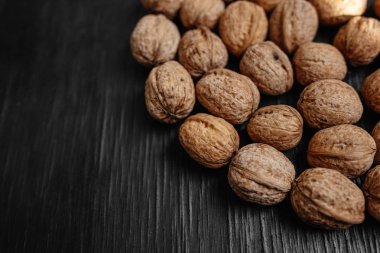 Bir sürü siyah bir ahşap zemin üzerine taze fındık. Tasarımcı için en iyi yöntemler. Fındık üzerinden güzel bir tasarım