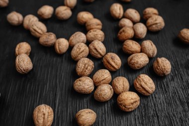 Bir sürü siyah bir ahşap zemin üzerine taze fındık. Tasarımcı için en iyi yöntemler