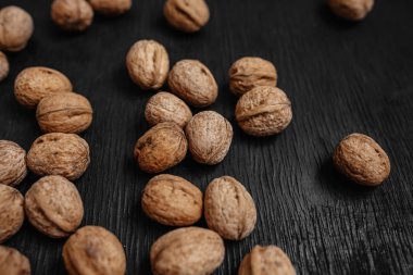 Bir sürü siyah bir ahşap zemin üzerine taze fındık. Tasarımcı için en iyi yöntemler