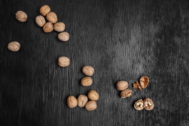 Bir sürü siyah bir ahşap zemin üzerine taze fındık. Tasarımcı için en iyi yöntemler