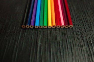 Siyah bir zemin üzerine birçok renkli kalemler. Yeni kalemler