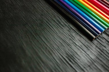 Siyah bir zemin üzerine birçok renkli kalemler. Yeni kalemler