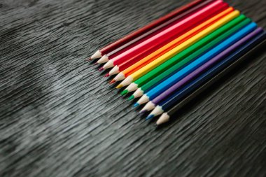 Siyah bir zemin üzerine birçok renkli kalemler. Yeni kalemler