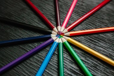 Siyah bir zemin üzerine birçok renkli kalemler. Yeni kalemler