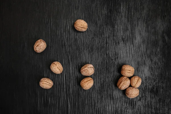 Lots of fresh nuts on a black wooden background. Best practices for designer