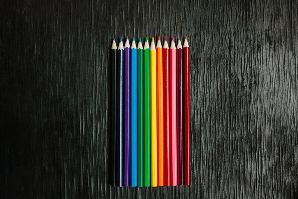 Many colored pencils on a black background. New pencils