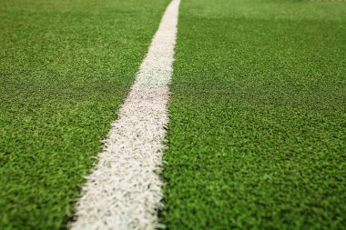 Yeşil suni çim futbol sahası. Yeşil futbol alan arka plan üzerinde beyaz çizgi.