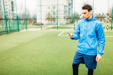 Genç bir adam spor çalış, futbol sahasında çalışır. Adam inşaat içinde açık, taze soluduğumuz hava.