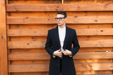 Şık, klasik kostüm, erkekte ahşap duvara yakın poz. İş tarzı, yaşam, çalışma.