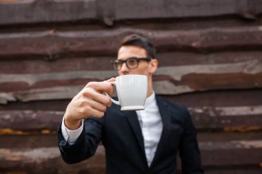 Yakışıklı adam, izole beyaz arka plan üzerinde beyaz bir kupa. Metin için yeterince boş alana