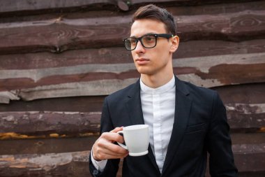 Yakışıklı adam, izole beyaz arka plan üzerinde beyaz bir kupa. Metin için yeterince boş alana