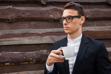 Yakışıklı adam, izole beyaz arka plan üzerinde beyaz bir kupa. Metin için yeterince boş alana