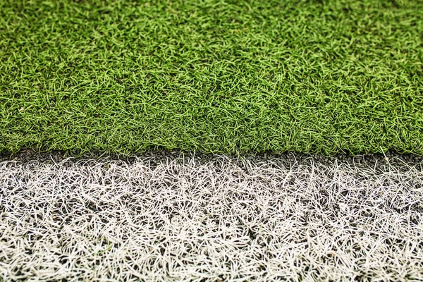 Groene kunstgras voetbalveld. De witte lijn op een groene voetbal veld achtergrond. — Stockfoto