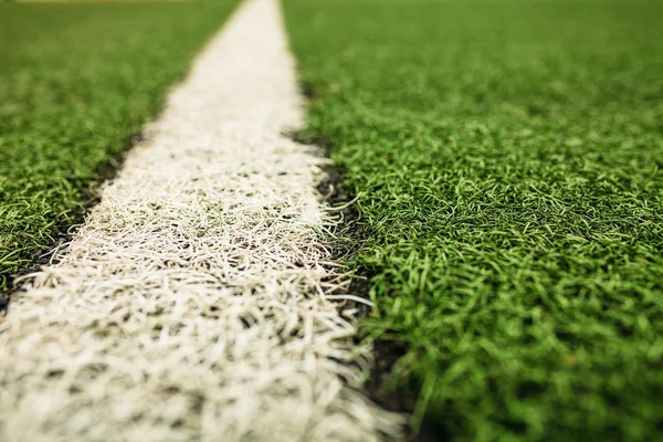 Campo de fútbol de césped artificial verde. La línea blanca sobre un fondo de campo de fútbol verde . — Foto de Stock