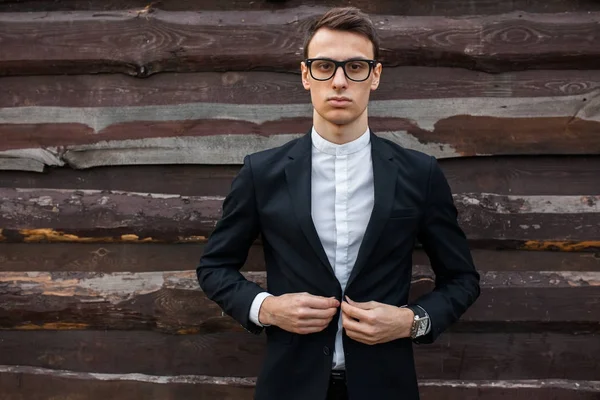 Şık, klasik kostüm, erkekte ahşap duvara yakın poz. İş tarzı, yaşam, çalışma.