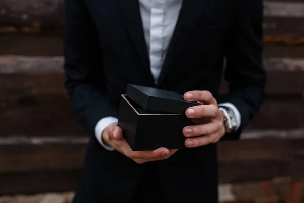 The guy holds in his hands a box, a gift or a product for sale. — Stock Photo, Image