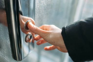 Asansörün düğmesine, düğme için izole Asansör, basma düğmesi Başlat ' için bekleyen kız ulaşan bir el başparmak presler