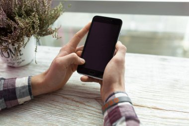 Telefon, kafede oturan adam elini tutan adamın