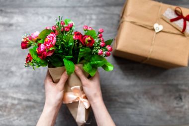 Sarılmış hediye, Sevgililer günü, romantik fotoğraf tutan el. Kalpleri ve hediyeler, reklam için uygun ile romantik gri ahşap arka plan