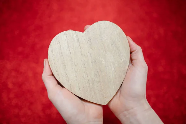 Egy csillogó piros háttér, hegyikristály, Valentin napi ajándék a második felében, egy romantikus fénykép, egy fából készült szív, piros háttéren, alkalmas a szöveg beillesztése — Stock Fotó