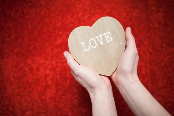 Un fondo rojo brillante, diamantes de imitación, regalo de San Valentín para la segunda mitad, una foto romántica, un corazón de madera sobre un fondo rojo, adecuado para la inserción de texto — Foto de Stock