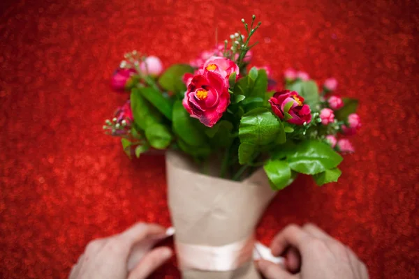 Día de San Valentín, florista mujer paquetes de un ramo de flores de rosas en una envoltura de papel con un arco en la mesa de madera, adecuado para la publicidad , — Foto de Stock