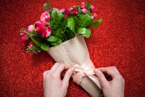 Día de San Valentín, florista mujer paquetes de un ramo de flores de rosas en una envoltura de papel con un arco en la mesa de madera, adecuado para la publicidad , — Foto de Stock