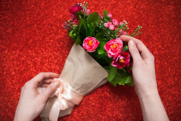 Día de San Valentín, florista mujer paquetes de un ramo de flores de rosas en una envoltura de papel con un arco en la mesa de madera, adecuado para la publicidad , — Foto de Stock