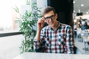 Gözlük ve pozitif bir ruh hali ve geniş bir gülümseme ile bir gömlek genç bir adam portresi