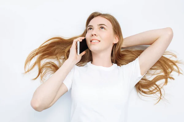 Beautiful young girl talking on the phone, in the Studio, isolated background, cheerful and positive — Stock Photo, Image