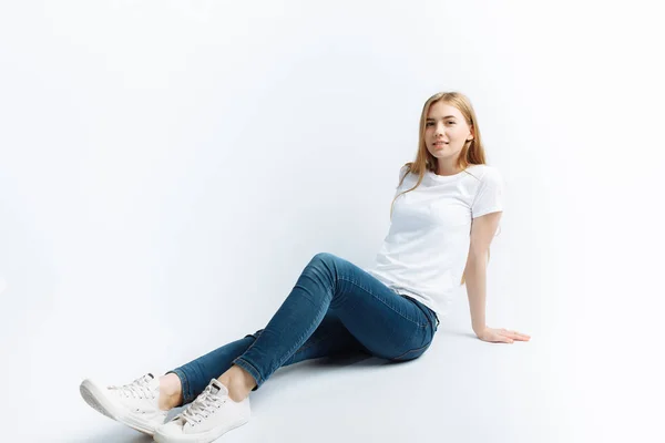 Chica joven posando y sonriendo, sobre un fondo blanco delgada rubia —  Fotos de Stock