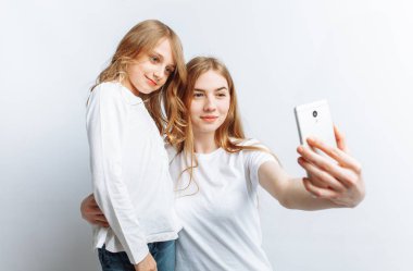 Anne ya da ablası yapar selfie küçük kız, mutlu bir aile fotoğraf stüdyosu, izole