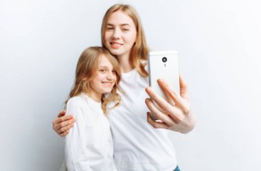 Anne ya da ablası yapar selfie küçük kız, mutlu bir aile fotoğraf stüdyosu, izole