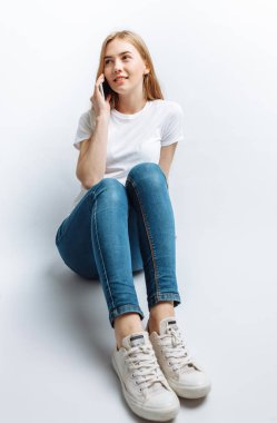 Güzel genç kız stüdyo, telefonda konuşurken arka plan, neşeli ve olumlu izole