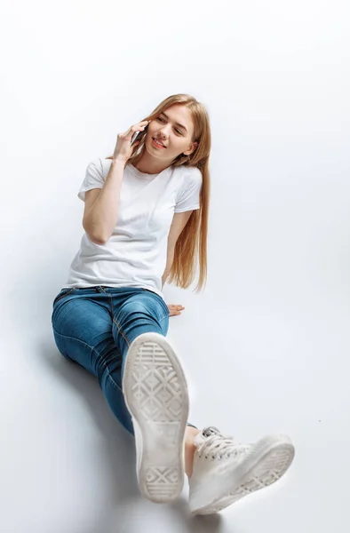 Mooi jong meisje praten aan de telefoon, in de Studio, geïsoleerde achtergrond, vrolijk en positief — Stockfoto