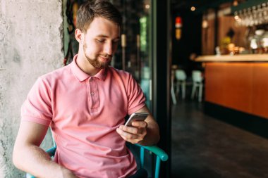 Çalışma, hipster alışveriş online, dizüstü bilgisayar ve telefon, kafede oturan genç adam