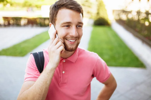 Young handsome man walking around town and talking on the phone, hipster Stock Picture