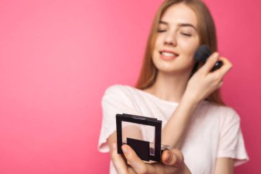 Genç güzel kadın ve bir fırça ve toz noktada mirro içinde görünüyor